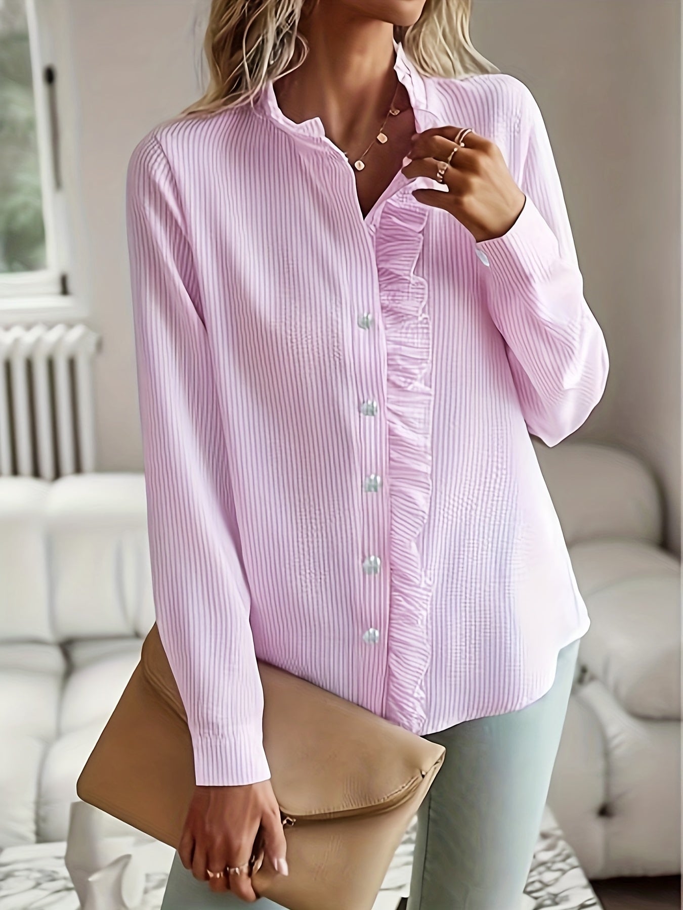 Camisa elegante de mulher às riscas com folhos, manga comprida, gola alta e detalhes de botões.