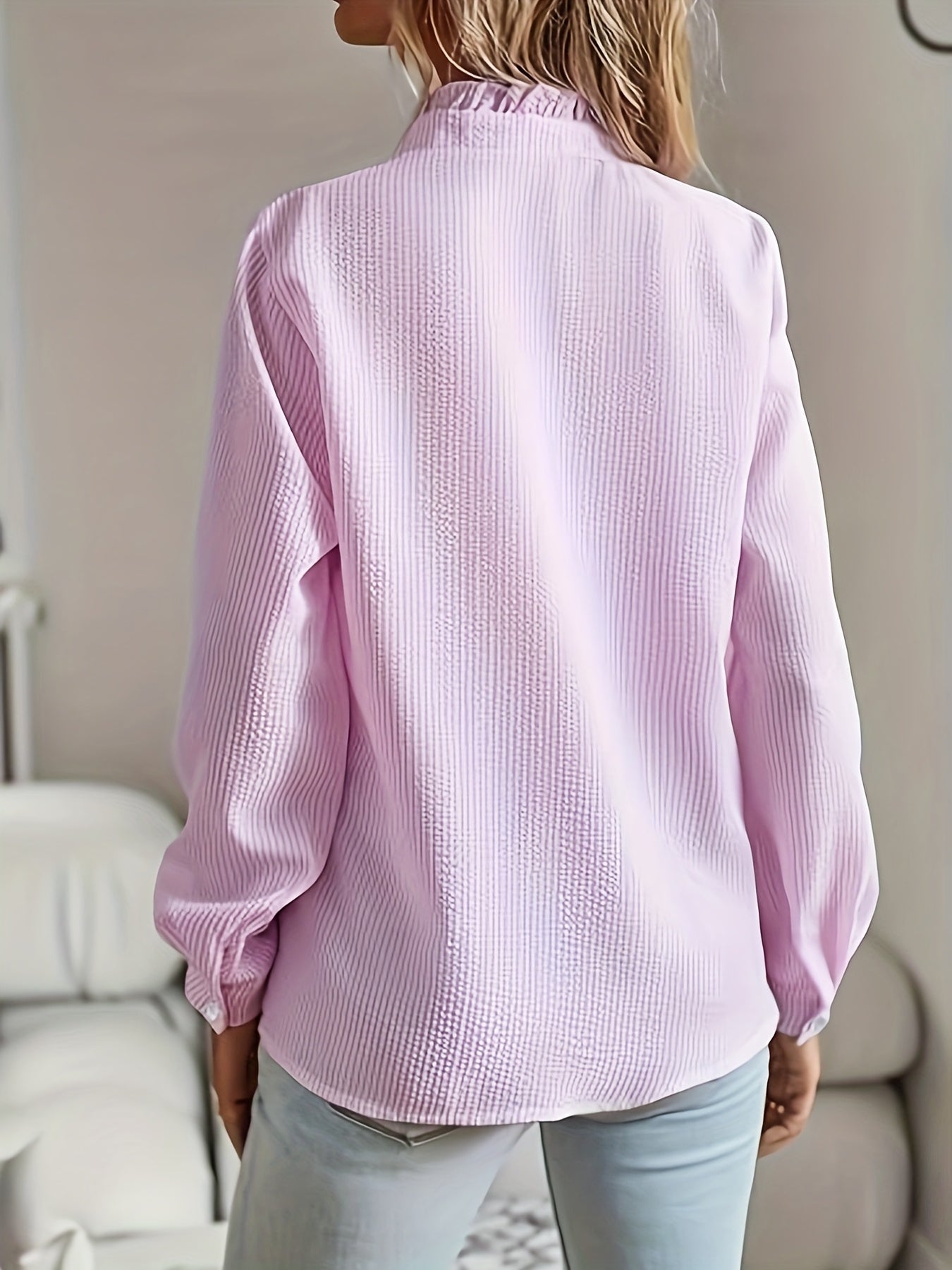 Camisa elegante de mulher às riscas com folhos, manga comprida, gola alta e detalhes de botões.